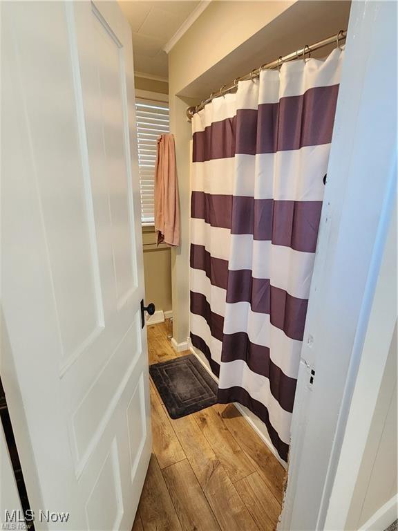 bathroom with walk in shower and ornamental molding