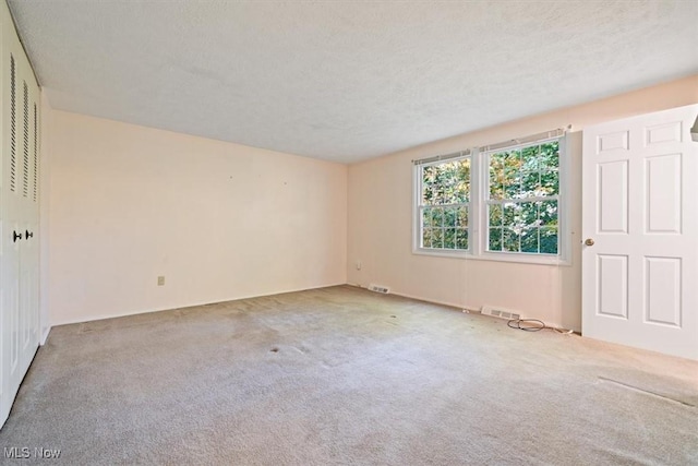 empty room featuring carpet flooring and a textured ceiling