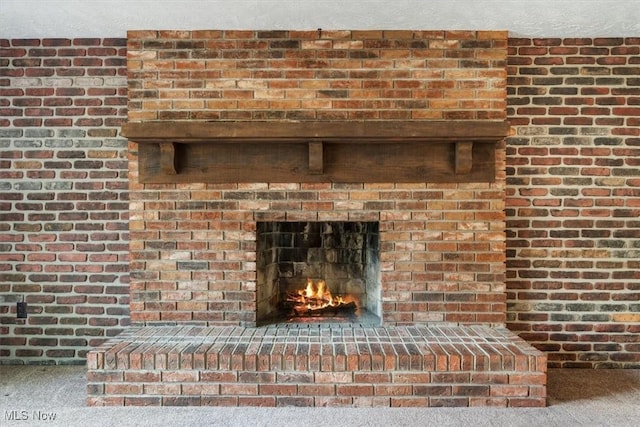 room details featuring carpet and a brick fireplace