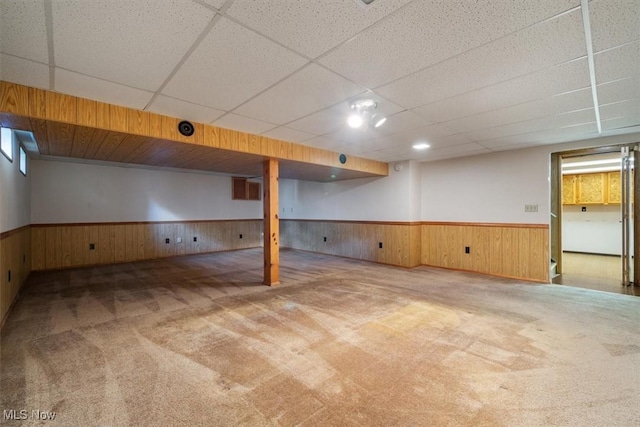 basement with carpet and a paneled ceiling