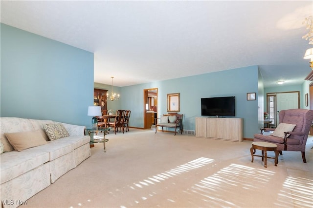 living room featuring light colored carpet and a notable chandelier