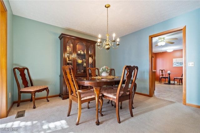 dining area with a chandelier and light colored carpet