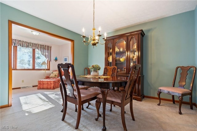 dining area with light colored carpet and an inviting chandelier