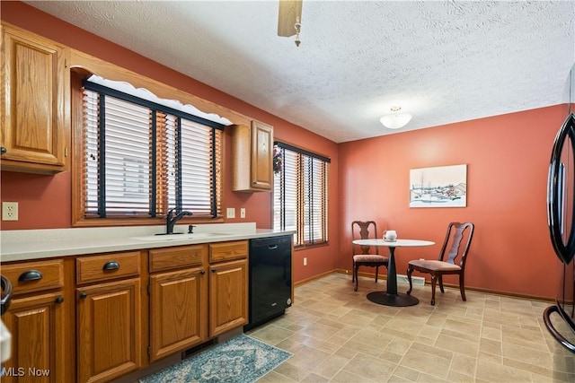 kitchen with sink, black dishwasher, and a textured ceiling