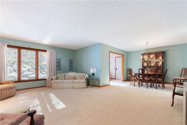 living room with a textured ceiling, light carpet, and a notable chandelier