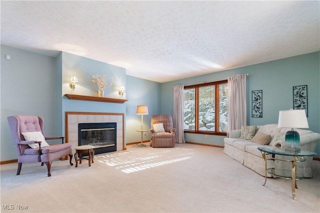 living room with a tile fireplace, a textured ceiling, and light carpet