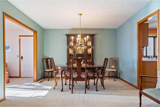 carpeted dining space with an inviting chandelier and a textured ceiling