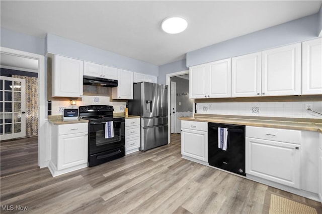 kitchen featuring decorative backsplash, white cabinets, black appliances, and light hardwood / wood-style flooring