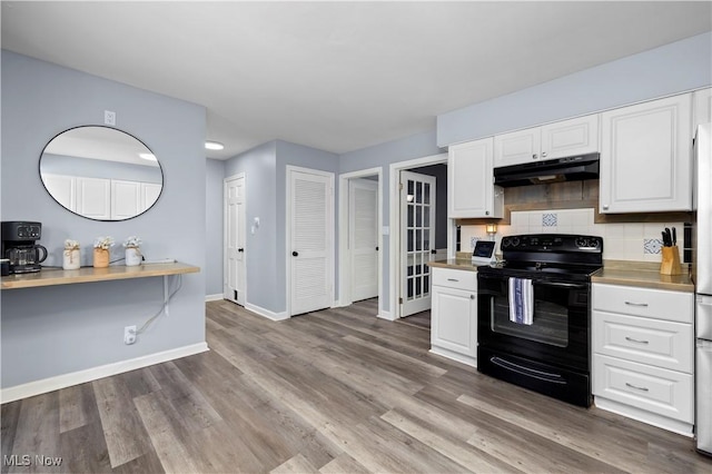 kitchen with black electric range oven, backsplash, white cabinetry, and dark hardwood / wood-style floors