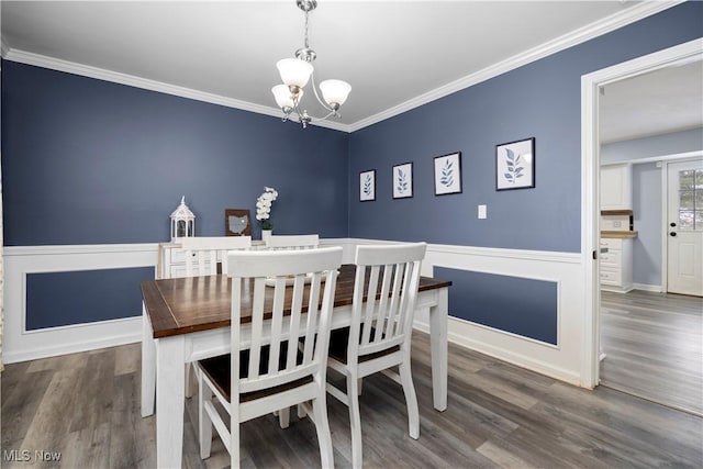 dining space featuring a chandelier, crown molding, and dark wood-type flooring