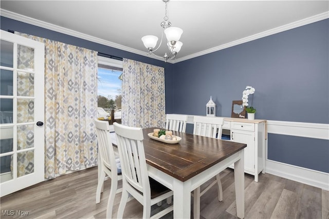 dining room featuring a chandelier, crown molding, and wood-type flooring