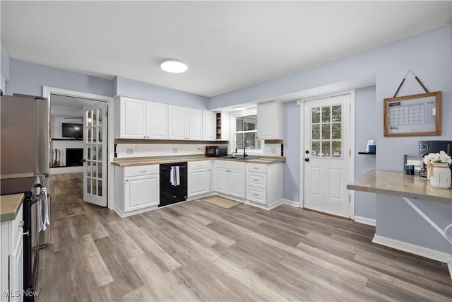 kitchen with light hardwood / wood-style floors, sink, white cabinets, and black appliances