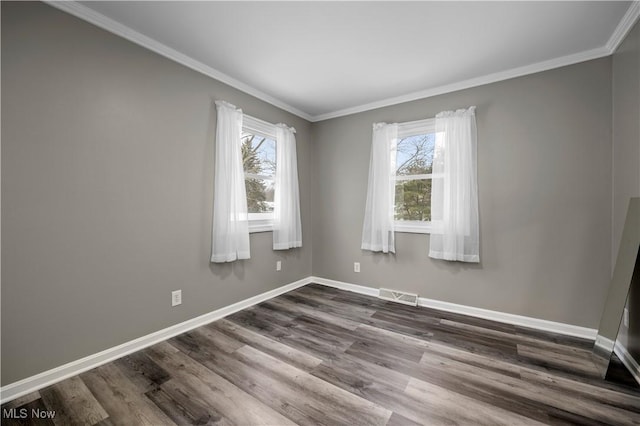 spare room with wood-type flooring, plenty of natural light, and ornamental molding