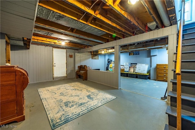 basement featuring wooden walls