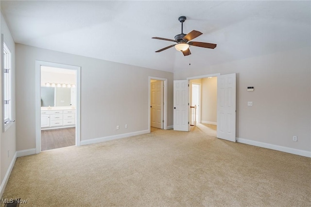 unfurnished bedroom with ceiling fan, light carpet, and ensuite bath