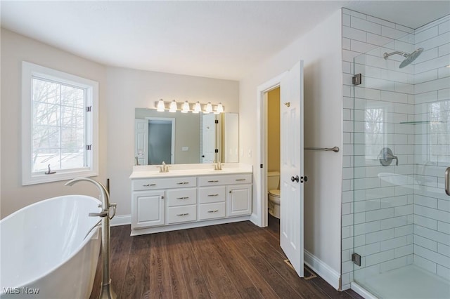 full bathroom featuring independent shower and bath, toilet, hardwood / wood-style floors, and vanity