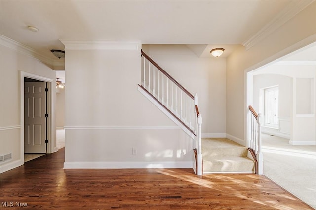 staircase featuring hardwood / wood-style floors and ornamental molding