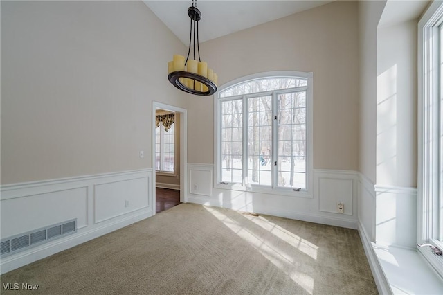 empty room with carpet, lofted ceiling, and a healthy amount of sunlight