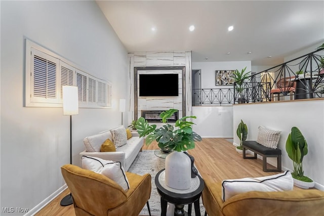 sitting room featuring a large fireplace and light hardwood / wood-style floors