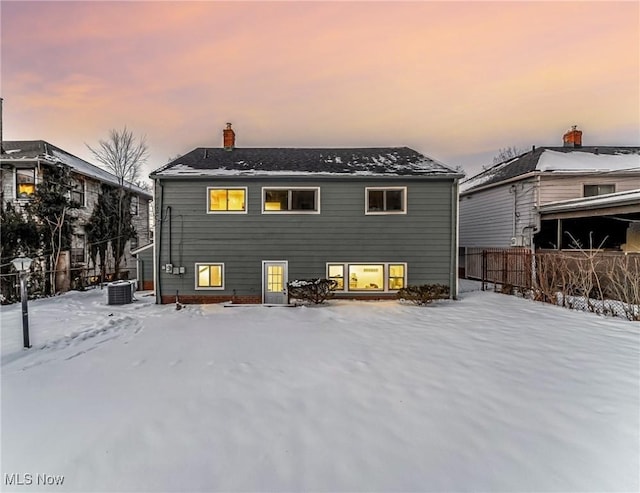 snow covered back of property with central AC unit