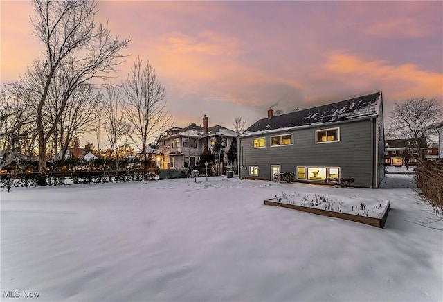 view of snow covered back of property