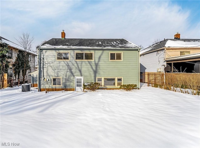 snow covered house with central air condition unit