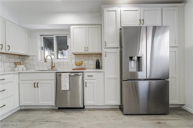 kitchen with white cabinetry, stainless steel appliances, sink, and tasteful backsplash