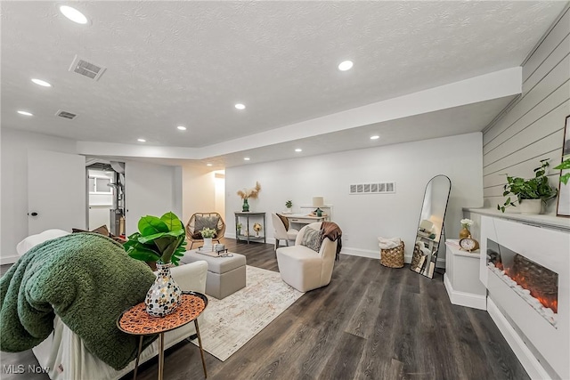 living room with dark wood-type flooring and a textured ceiling