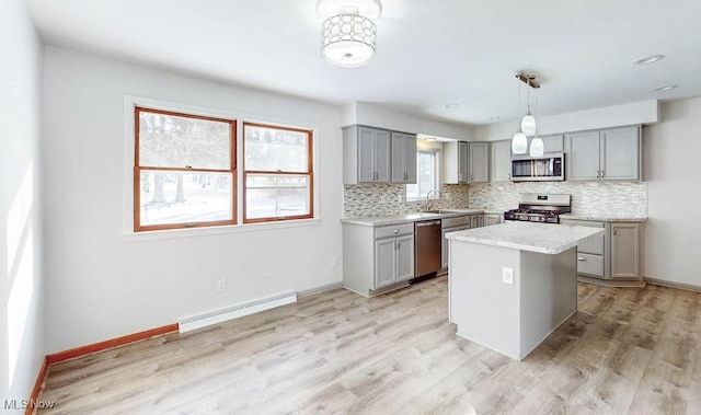 kitchen featuring appliances with stainless steel finishes, a baseboard radiator, decorative light fixtures, a kitchen island, and gray cabinets