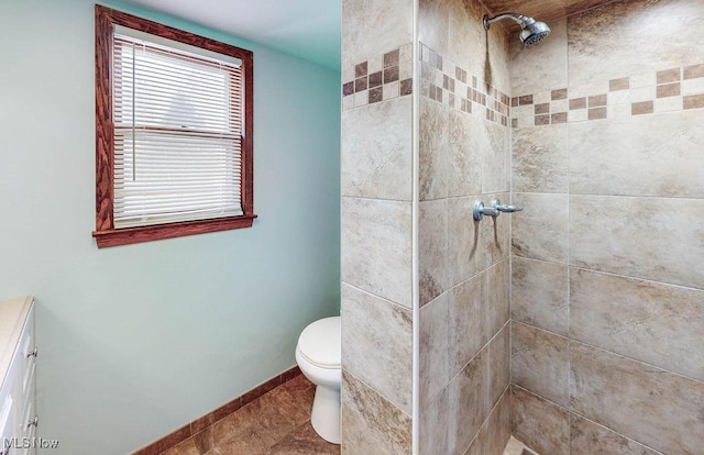 bathroom with tiled shower and toilet