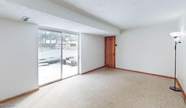 carpeted spare room featuring a textured ceiling