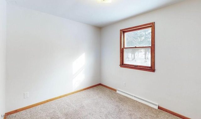 carpeted spare room with a baseboard radiator