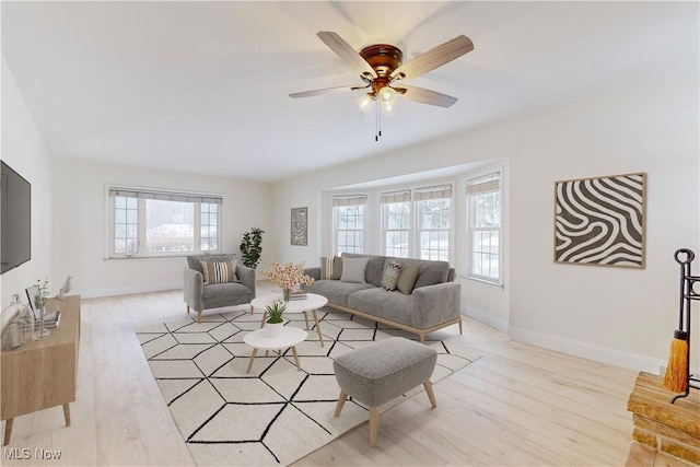 living room with light hardwood / wood-style flooring and ceiling fan