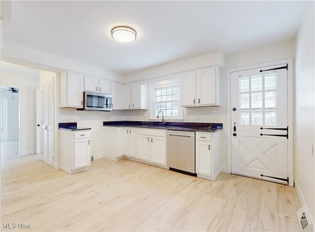 kitchen featuring sink, white cabinetry, appliances with stainless steel finishes, and light hardwood / wood-style flooring