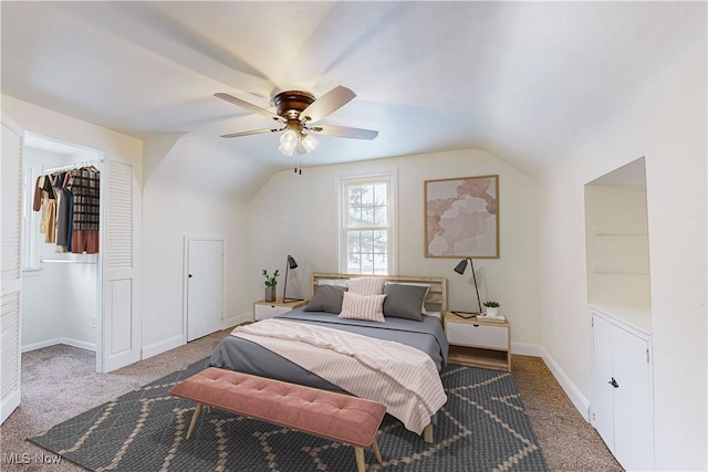 bedroom with lofted ceiling, carpet flooring, a closet, and ceiling fan