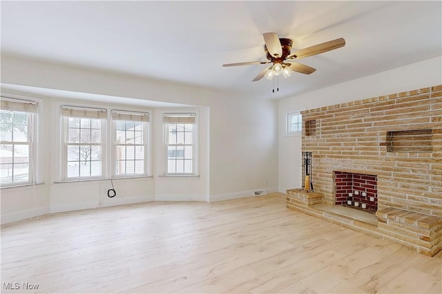 unfurnished living room with ceiling fan, light hardwood / wood-style floors, and a fireplace