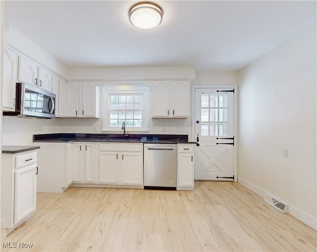 kitchen featuring sink, light hardwood / wood-style flooring, white cabinets, and appliances with stainless steel finishes