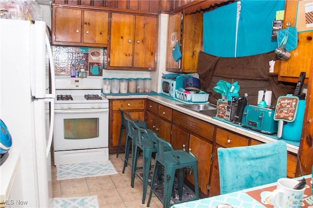 kitchen with white appliances and light tile patterned floors