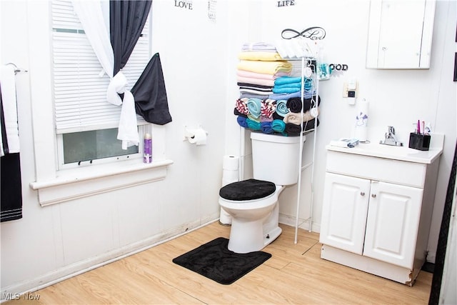 bathroom with hardwood / wood-style floors, toilet, and vanity