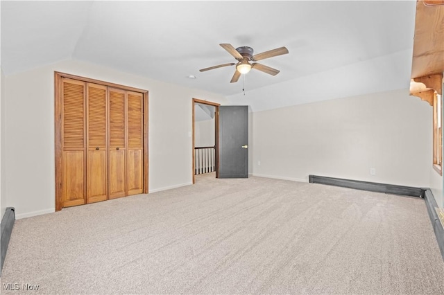 unfurnished bedroom with ceiling fan, vaulted ceiling, and light carpet