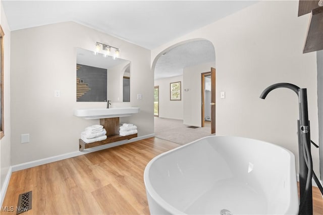 bathroom with a bathing tub and wood-type flooring