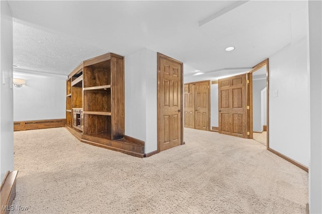 interior space featuring a textured ceiling and carpet flooring