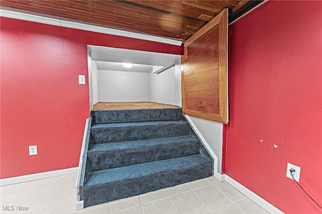 stairs featuring crown molding, tile patterned floors, and wood ceiling