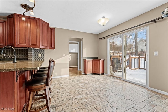 kitchen featuring sink, decorative backsplash, and a breakfast bar