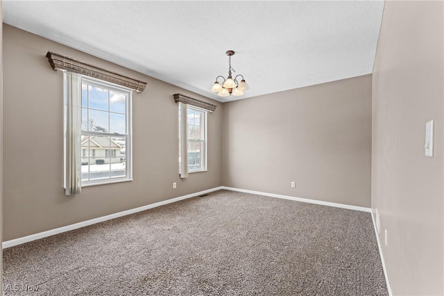 spare room featuring an inviting chandelier and carpet floors