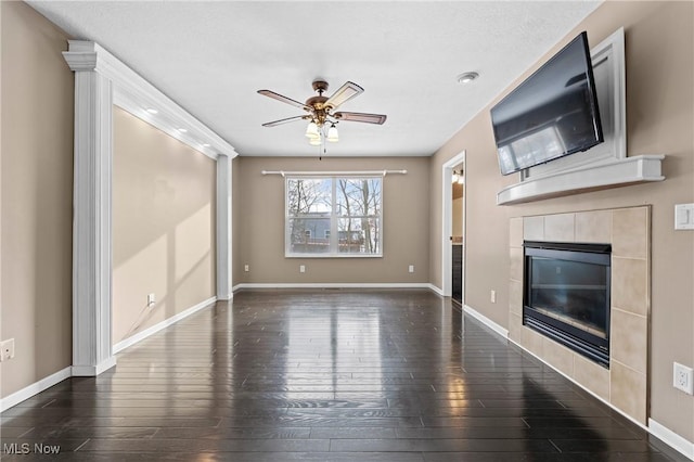 unfurnished living room featuring ceiling fan, a tile fireplace, and dark hardwood / wood-style flooring