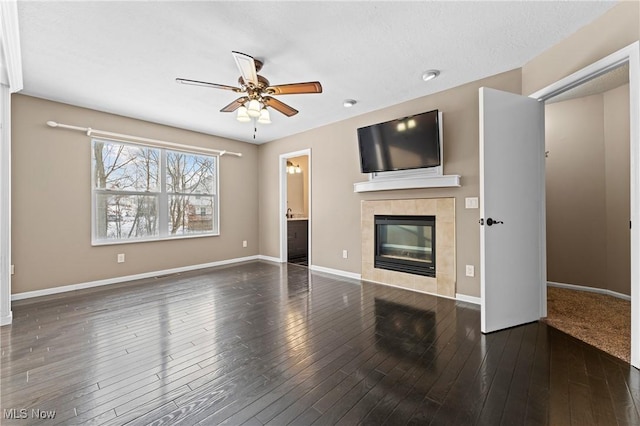 unfurnished living room featuring ceiling fan, dark hardwood / wood-style floors, and a fireplace