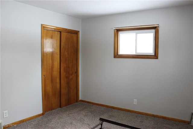 unfurnished bedroom featuring a closet, carpet flooring, and baseboards