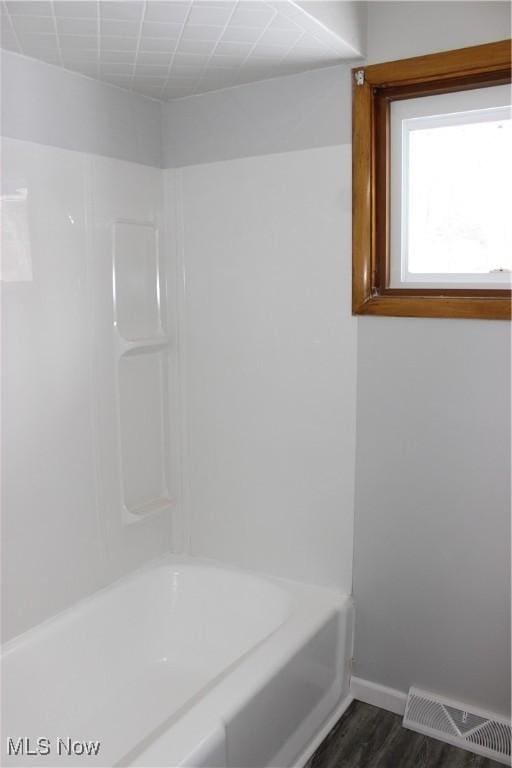 bathroom featuring hardwood / wood-style floors and  shower combination