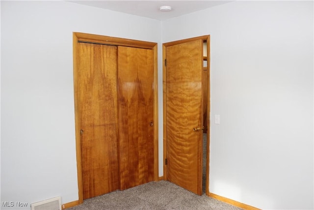 unfurnished bedroom featuring a closet and light carpet